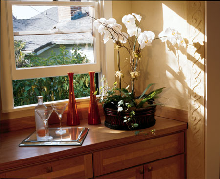 This quiet corner of the family room displays several of Kelly’s natural remodeling choices: a window to let in sunlight, wheatboard cabinets with a bamboo countertop and bamboo matting on the doors, and earth-plastered walls with a decorative pattern pressed into thickened plaster around the doorway.